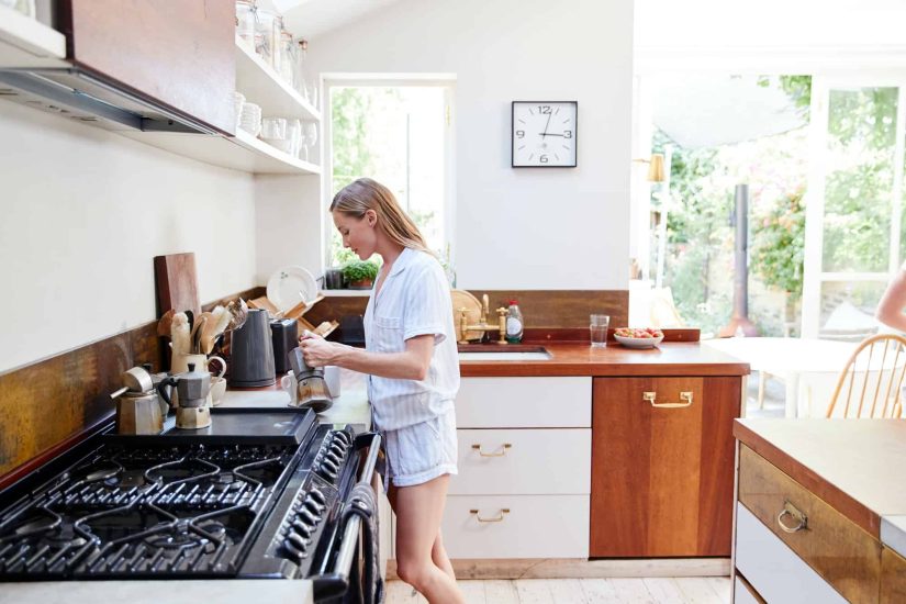 Woman Wearing Pajamas At Home In Kitchen Making Fresh Coffee Woman Wearing Pajamas At Home In Kitchen Making Fresh Coffee